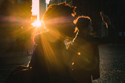 People standing in city during sunset