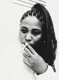 Close-up portrait of a young woman smoking