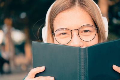 Close-up portrait of woman holding book
