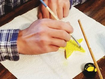 Close-up of baby hand holding table