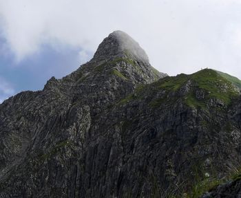 Low angle view of rocky mountain against sky