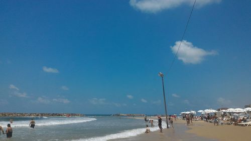 People at beach against sky