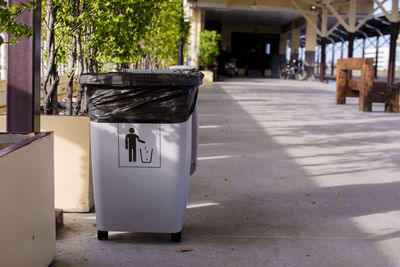 Garbage bin on footpath in city