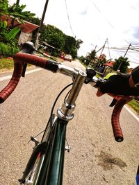 Man riding bicycle on tree against sky