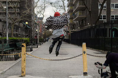 Photographer photographing man performing stunt in city