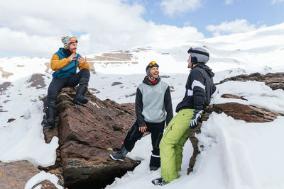 People on snowcapped mountains against sky