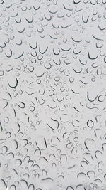 Full frame shot of raindrops on glass window