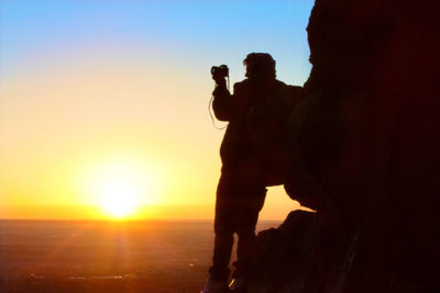 Silhouette man standing against sky during sunset