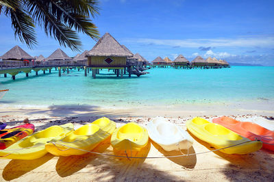 Lounge chairs by swimming pool at beach against sky