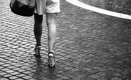 Low section of woman walking on footpath