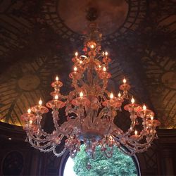 Low angle view of illuminated chandelier hanging from ceiling