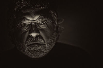 Portrait of man against black background