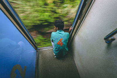Rear view of boy on car window