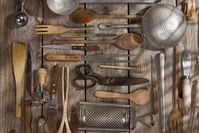 Various kitchen utensils hanging on wood