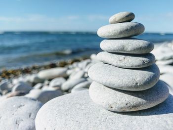 Stack of pebbles on beach against sky