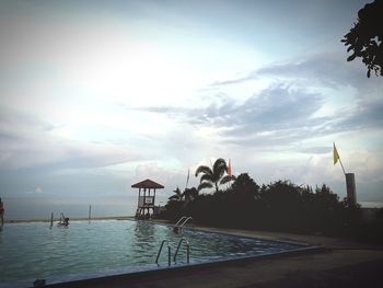 Swimming pool by sea against sky