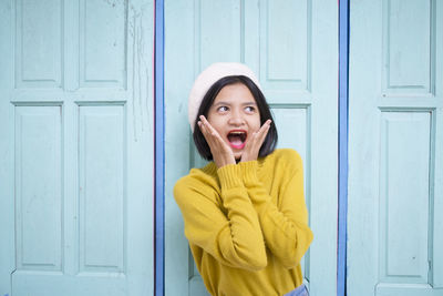 Portrait of woman with yellow eyes closed door