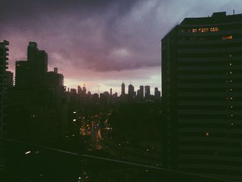 Buildings in city against sky during sunset