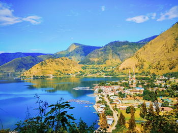 Scenic view of lake and mountains against blue sky