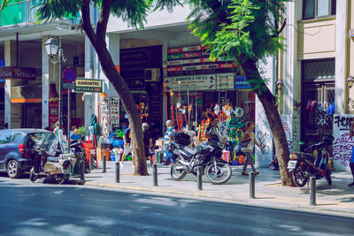 People riding bicycles on street against buildings in city