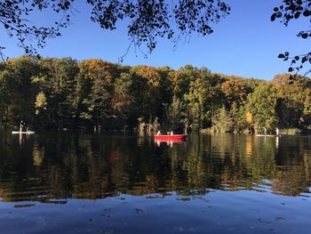 Scenic view of lake by trees against sky