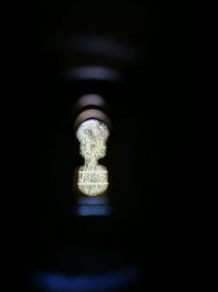 Close-up of illuminated lamp against black background