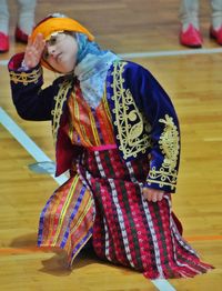 Girl in folk dance dress performing on stage