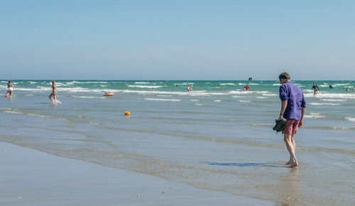 People on beach against sky