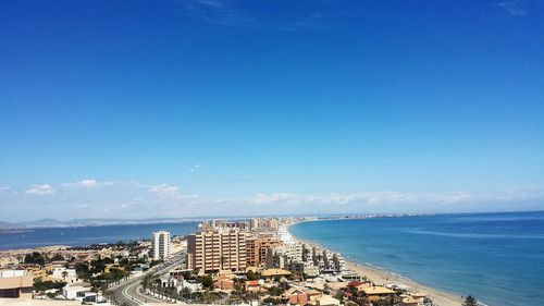 Buildings in city by sea against sky