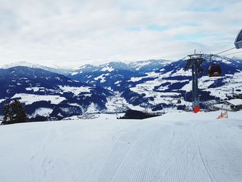 Overhead cable car over snowcapped mountains against sky