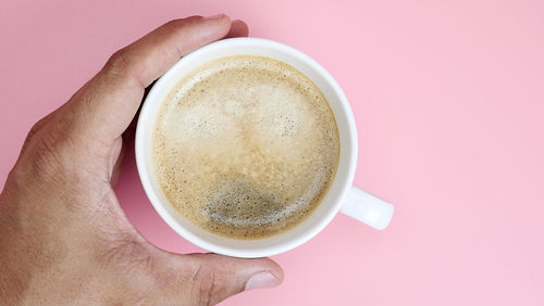 Close-up of hand holding coffee cup