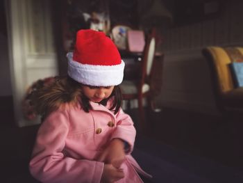 Girl wearing santa hat at home