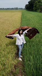 Rear view of woman standing on grassy field