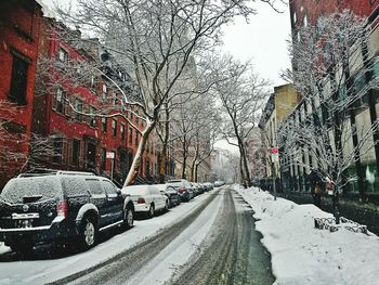 Snow covered road in city