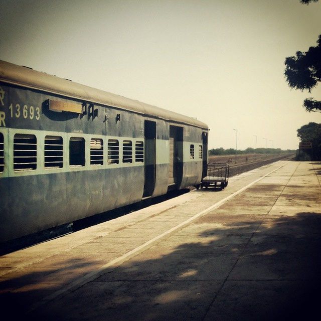 transportation, architecture, built structure, clear sky, building exterior, the way forward, road, road marking, copy space, empty, street, diminishing perspective, outdoors, no people, day, railroad track, sky, vanishing point, text, rail transportation