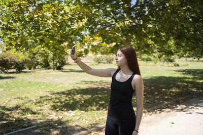 Rear view of woman standing against trees