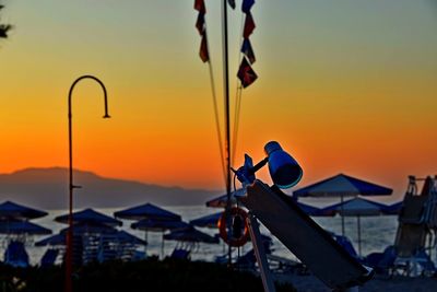 Close-up of silhouette flags against orange sky