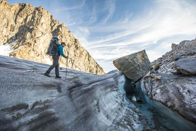 Rear view of man on rock formation against sky