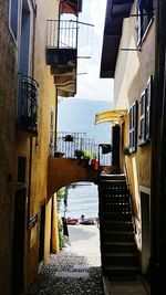 Alley amidst buildings in city against sky