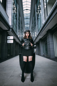 Full length portrait of woman standing against building