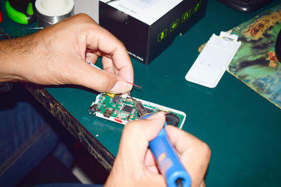 Close-up of man using smart phone on table