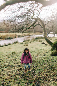 Full length portrait of woman standing on tree