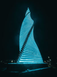 Low angle view of illuminated building against sky at night