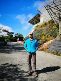 Full length portrait of man standing on road