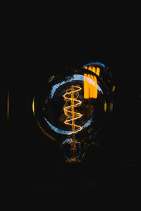 Close-up of illuminated light bulb at night