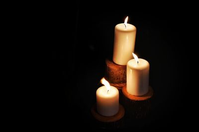 High angle view of illuminated candle against black background