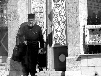 Portrait of man standing against building