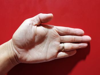 Close-up of hand against red background