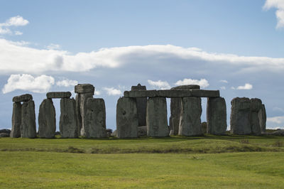 Built structure on landscape against cloudy sky