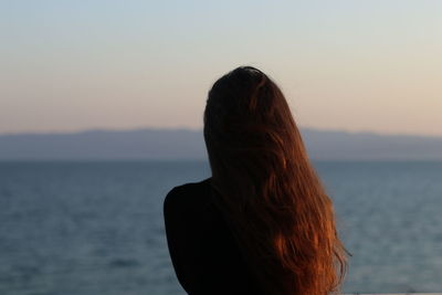 Rear view of woman looking at sea against sky